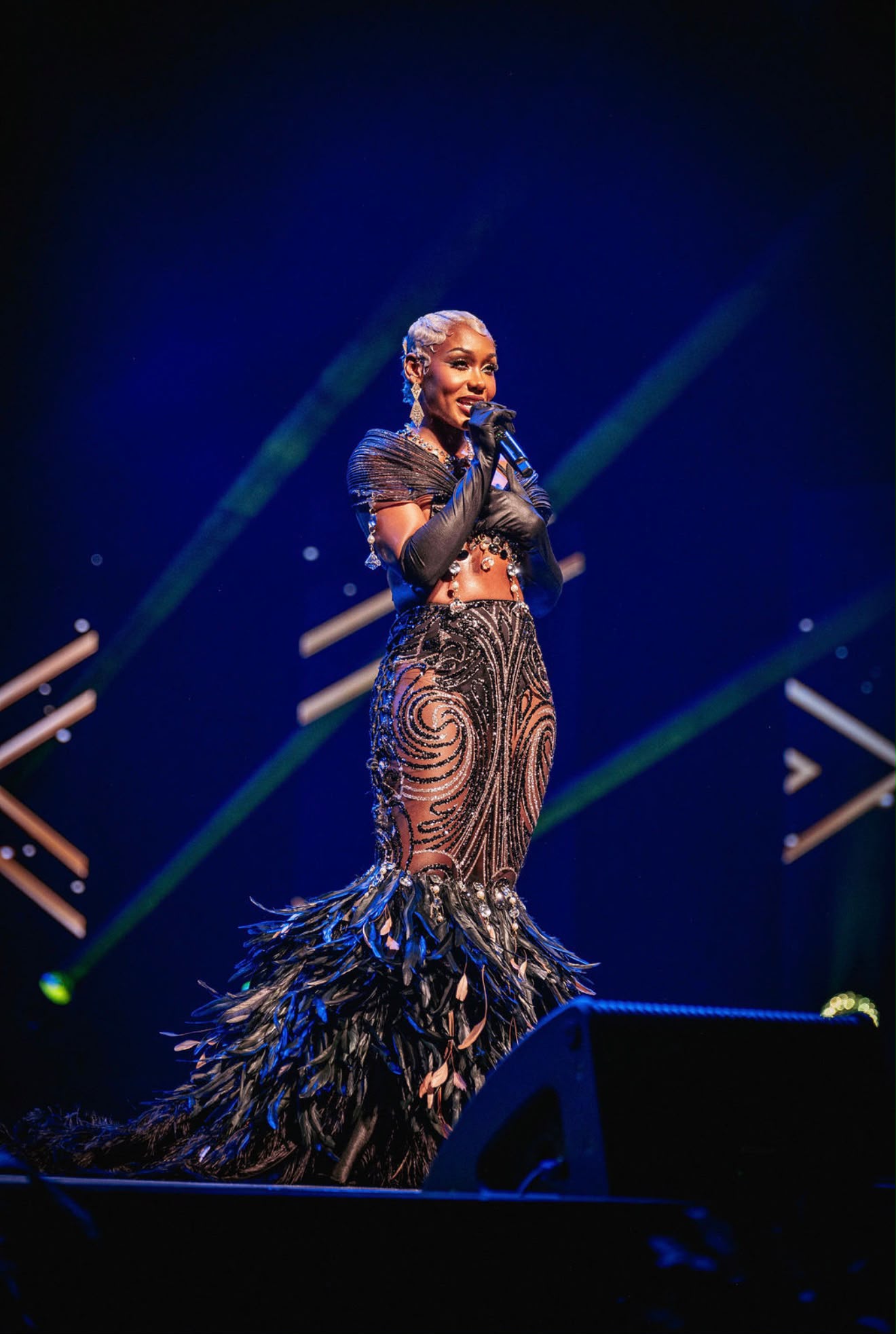 Caribbean Music Awards artist performing onstage in a black feathered gown