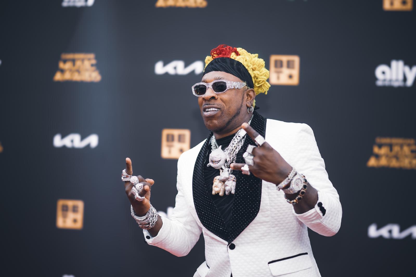 A guest in a white suit at the 2026 Caribbean Music Awards red carpet