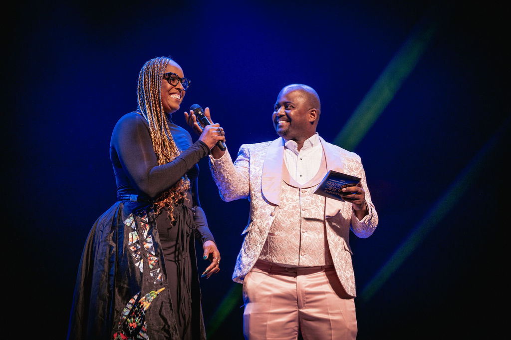 A presenter and artist sharing a moment onstage at the 2026 Caribbean Music Awards